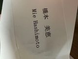 a person holding a piece of paper with chinese writing on it