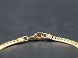 a close up of a gold bracelet on a black surface