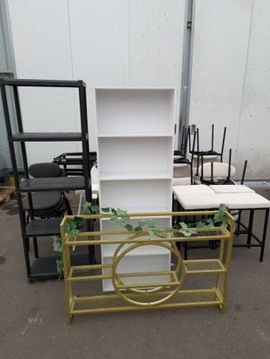 many different chairs and tables in a warehouse area