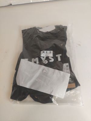 un t-shirt noir posé sur une table blanche, à côté d'une paire de ciseaux et d'une paire de ciseaux