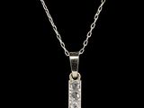 un pendentif en forme de croix en or blanc serti de diamants, monté sur une chaîne