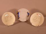 three plates with drawings on them are sitting on a table