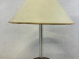 une lampe de table surmontée d'un abat-jour blanc