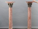a woman that is standing next to a pair of pillars