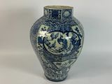 a blue and white vase sitting on a white surface