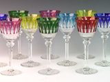several different colored wine glasses are lined up in a row