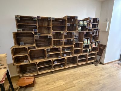 a wooden shelf with many crates on it in a room