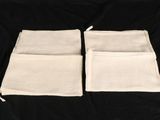 two white cloth bags on a black background