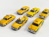Des taxis jaunes sont alignés en rang sur une surface blanche