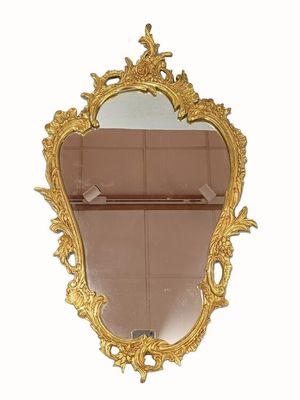 un miroir avec un cadre doré accroché au mur