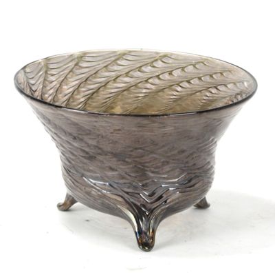 a glass bowl sitting on a stand on a white surface