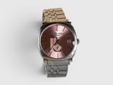 une montre posée sur une surface blanche