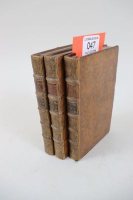 plusieurs vieux livres sont empilés sur une surface blanche