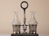 two glass vases sitting on top of a metal stand