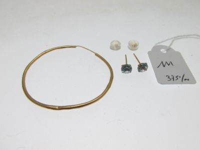 une photo représentant une paire de boucles d'oreilles créoles en or et une paire de boucles d'oreilles en perles