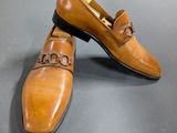 a close up of a pair of brown shoes on a gray surface