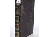 an old book sitting on top of a table next to a white background