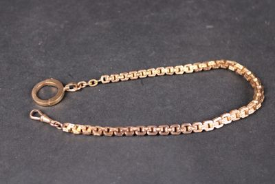 a close up of a gold chain bracelet on a black surface