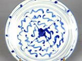 une assiette bleue et blanche sur laquelle est représentée une horloge
