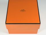 an orange box with a logo on it sitting on a white surface