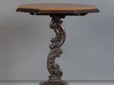 une vieille table en bois avec un plateau sculpté et un piètement en bois