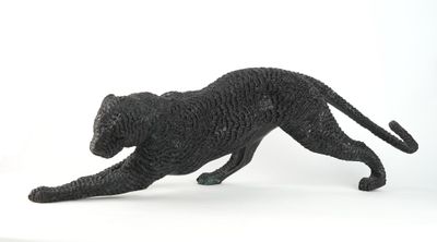 figurine of a black cat running on a white surface