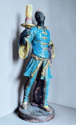 a statue of a man holding a candle in his hand