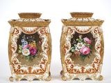 two vases with flowers painted on them sitting side by side