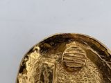 an image of a gold coin sitting on top of a white surface