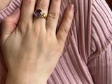 a woman holding her hand to her chest with a ring on it