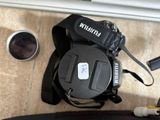a black camera with a black strap and a white button