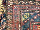 a close up of a rug with a red, blue, and yellow design