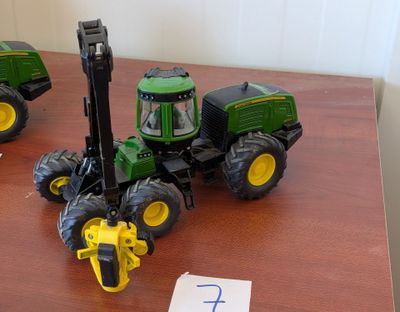 deux tracteurs miniatures posés sur une table, avec un chiffre inscrit sur la table