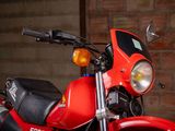 a red motorcycle parked in front of a brick wall