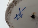 a close up of a vase with flowers on it