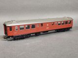 a red train car that is sitting on a gray surface
