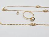 a close up of a gold chain with a ring on it