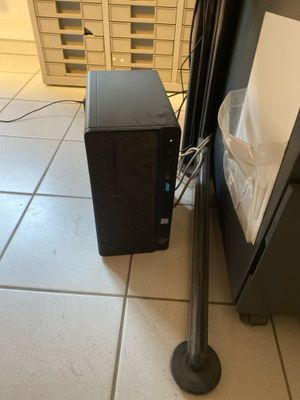 a small black computer on the floor next to a metal pole