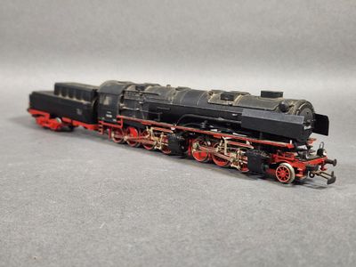un train noir et rouge sur un fond gris