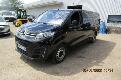 une photo d'une camionnette noire garée devant un immeuble