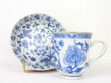 une tasse et une soucoupe bleues et blanches posées l'une à côté de l'autre