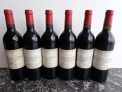six bottles of red wine are lined up in a row