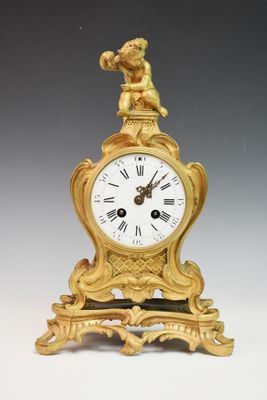 une horloge en or surmontée d'un oiseau