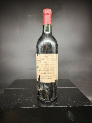 une vieille bouteille de vin posée sur une table noire