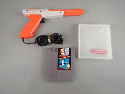 un pistolet orange et blanc et un jeu Nintendo posés sur une table