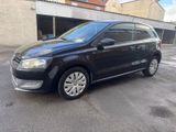 the black volkswagen polo is parked in front of a building
