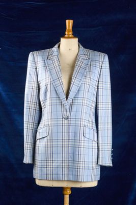 le costume est posé sur un mannequin, devant un fond bleu
