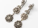 a pair of antique silver and diamond earrings on a white background