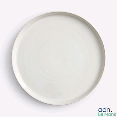 a white plate on a table with a spoon and fork
