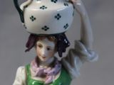 a figurine of a woman with a pot on her head
